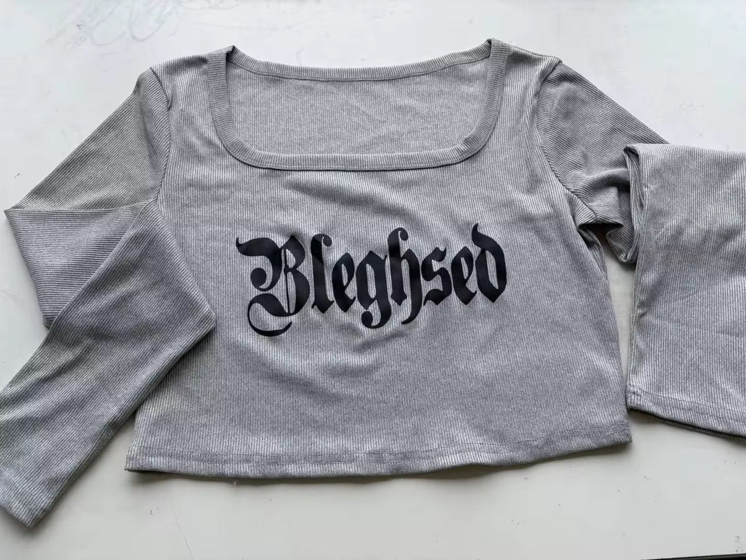 Gray crop top with 'Bleghsed' text on a light background