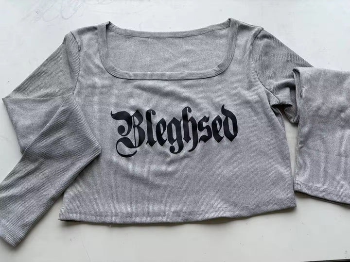 Gray crop top with 'Bleghsed' text on a light background